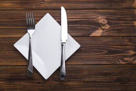 Empty white plate with knife and fork. view from top