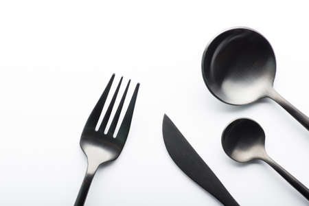 Cutlery set with black fork, knife and spoon isolated on white backgroundの写真素材
