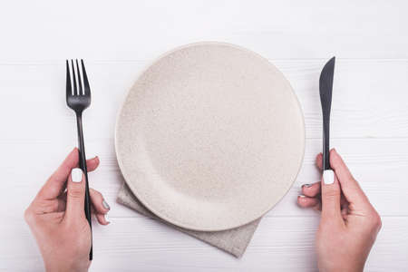 woman hand with knife and fork. top view of plate, wooden tableの写真素材