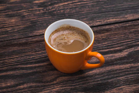 orange coffee cup on old wooden table. aroma beverageの写真素材