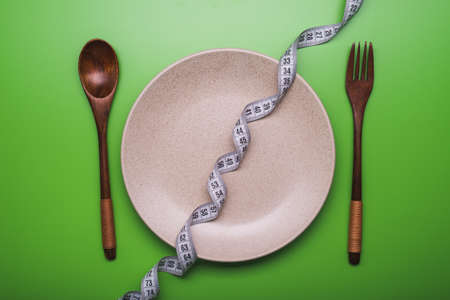 weight loss concept. plate with fork, knife and spoon on backgroundの写真素材