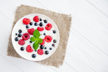 tasty yogurt with raspberry on wood white table. dessert food breakfastの写真素材