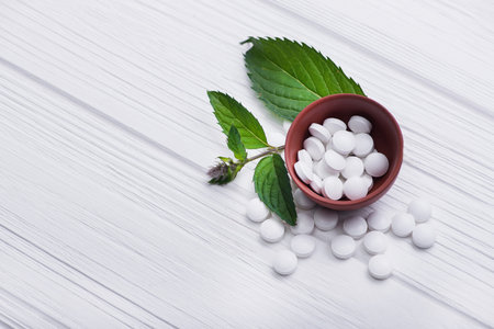 medicine herbal pills with leaf on white table. alternative organic therapy