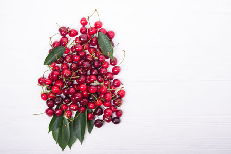 fresh red cherry on white wooden background. top view