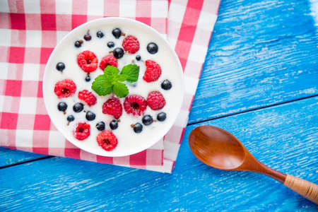 sweet breakfast with healthy food with fruit and yogurt on blue wood tableの写真素材