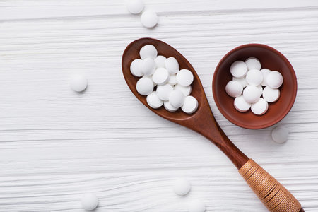 white medical pills on wooden spoon. medicine backgroundの写真素材