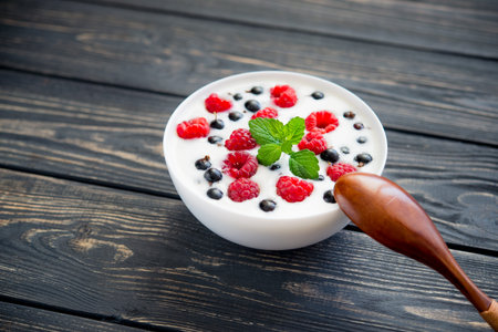 fresh yogurt with raspberry and green mint on wooden table. sweet dessert foodの写真素材