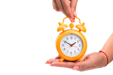 woman holds an alarm clock in her hands isolated on white background, time to breakfast or relax