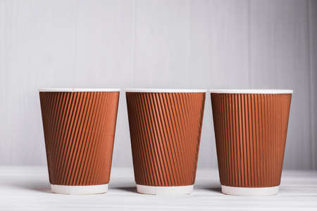 paper coffee cups on white wood table, takeaway drink containerの写真素材