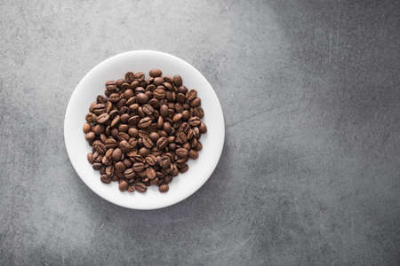 white coffee cup with roasted beans on stone table backgroundの写真素材