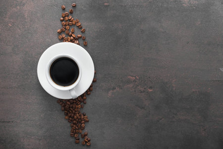 white ceramic cup with black coffee and ground grains on stone tableの写真素材