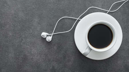 White cup of coffee with headphone on a stone table. break music concept. top view with copyspaceの写真素材