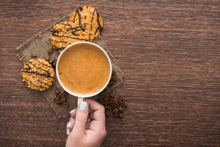 morning coffee cup with chocolate cookies on a wooden tableの写真素材