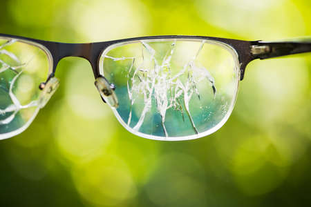 broken glasses on the green background of nature. concept of failure on the streetの写真素材