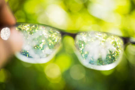 poor sight on the street.all is blurry. eyeglasses in handの写真素材