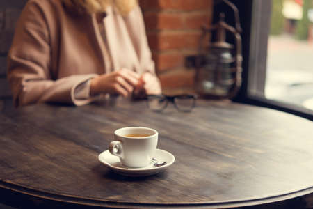woman with white coffee cup on a table. lifestyle of business  lady. breakfast in the restaurantの写真素材