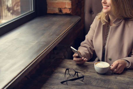woman with white coffee cup on a table. lifestyle of business  lady. breakfast in the restaurantの写真素材