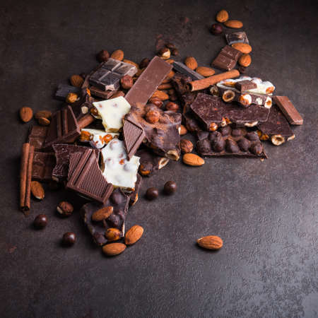 Pile of chocolate bars with nuts on a stone backgroundの写真素材