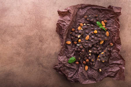 tasty chocolate bars with nuts, fresh mint and almond on a stone background. Sweet food の写真素材