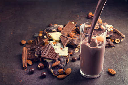 pouring cocoa glass drink with chocolate bars on a backgroundの写真素材