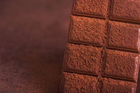 sweet chocolate bars with cocao powder on a tableの写真素材