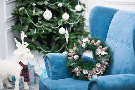 Christmas green wreath with pine cones and wooden stars on the armchairの写真素材