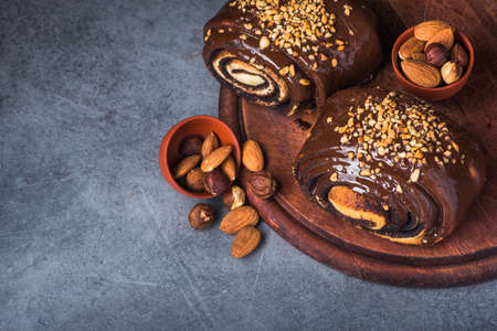 bun in chocolate and nuts on a stone backgroundの写真素材