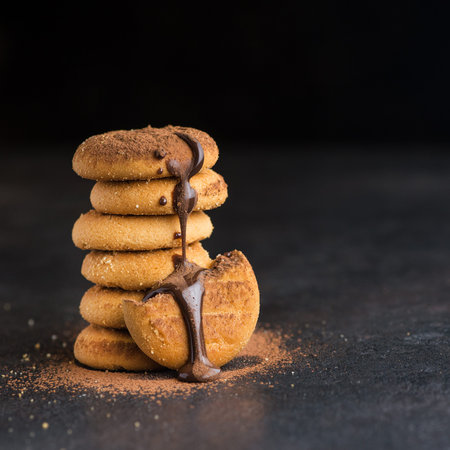 Sweet biscuit poured with chocolate on a black background