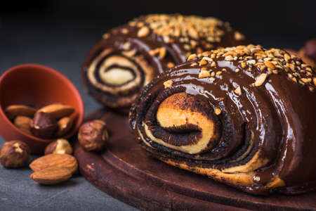 bun in chocolate and nuts on a stone backgroundの写真素材