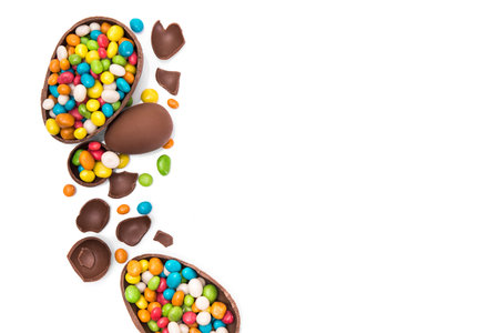 easter chocolate egg with colored candy isolated on white background. top view