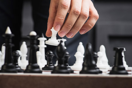 a man plays chess and holds a pawn in his hands