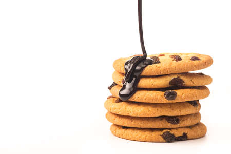 sweet cookies with raisin pouring chocolate sauce isolated on a white backgroundの写真素材