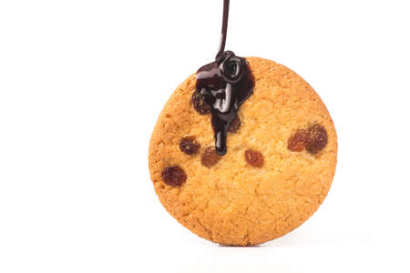 sweet cookies with raisin pouring chocolate sauce isolated on a white backgroundの写真素材