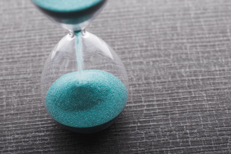 Retro hourglass with two transparent flask with sand on background. Time passing concept
