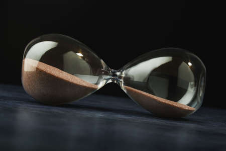 Time on the hourglass stopped. Clock on table. Pause in business, collapse.の写真素材