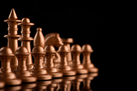 gold chess pieces with rhythm of pawns. Selective focus. Black glossy surface
