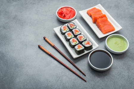 Set of sushi with ingredients salmon, ginger, wasabi and chopstick on stone background. delicious japan food 
