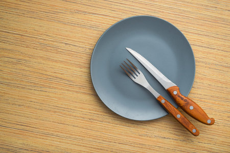 Metal fork and knife on a wooden table. arrangement of cutlery after meals. top viewの写真素材
