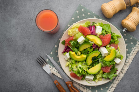 Fresh salad with avocado and grapefruit, glass of juice on a lunch. health eating concept