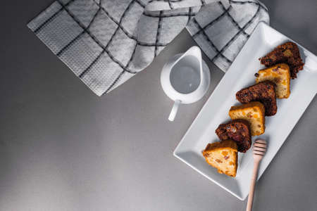 Sweet honey cake on white plate with teapot. top viewの写真素材