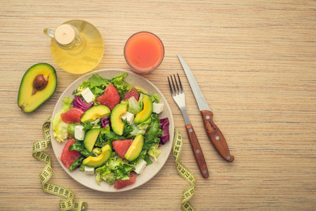 Fresh salad with avocado and fruits on a wooden table. Tasty morning breakfast. healthy diet food....