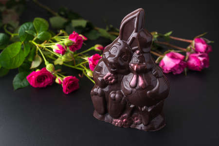 Sweet chocolate bunny with rose flowers on background. a gift for valentine's day or a woman's dayの写真素材