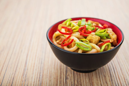 Udon noodles with red chilli pepper on wooden table. Spicy  japanese foodの写真素材