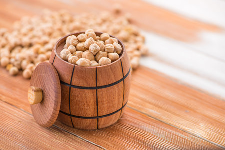 uncooked organic chickpeas in a barrel on a wooden table. vegetarian foodの写真素材