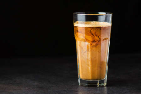 Iced latte coffee glass on a black tableの写真素材