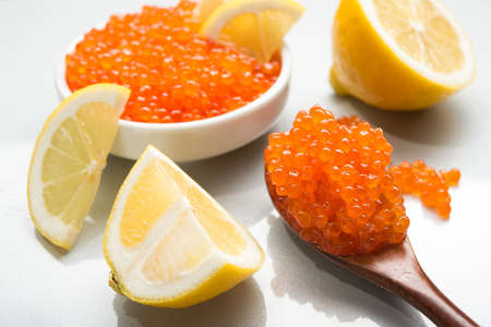 Red caviar witl slice lemon in a bowl isolated on a white background.の写真素材