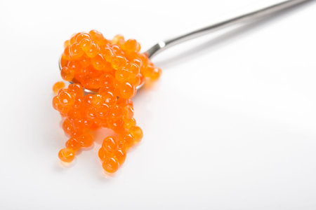 Red caviar on a spoon isolated on a white background. gourmet seafoodの写真素材