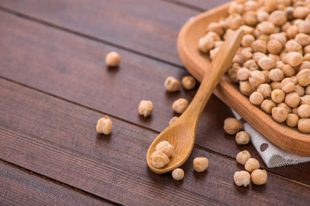 raw organic chickpeas in a wooden plate. organic bean の写真素材