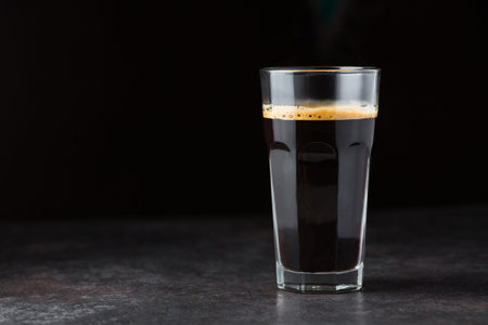 Hot espresso coffee glass on black background