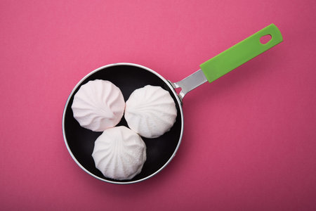 Tasty sweet zephyr in a pan and pastel pink background. の写真素材